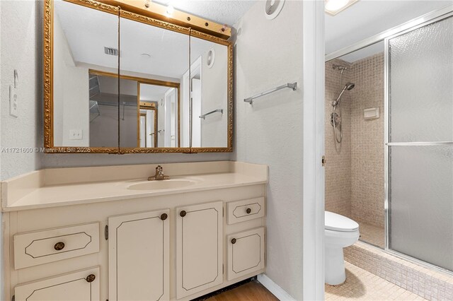 bathroom featuring walk in shower, vanity, and toilet