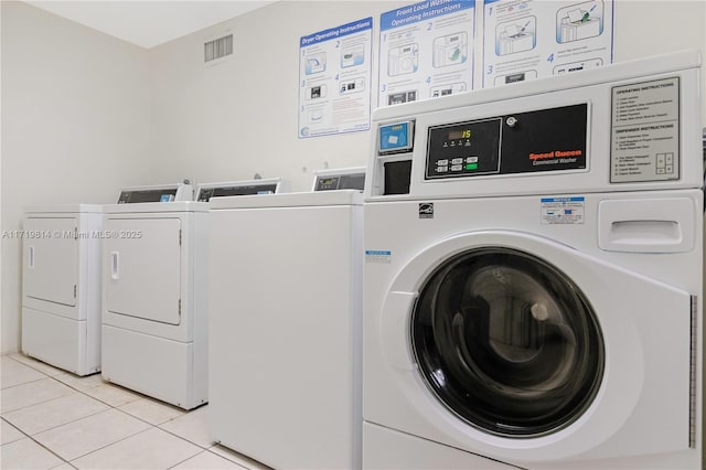 laundry room with light tile patterned floors and washing machine and clothes dryer