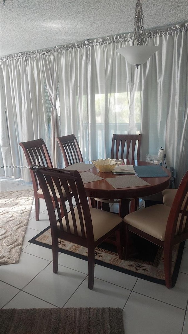 dining room with light tile patterned flooring and a textured ceiling