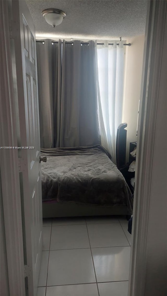 bedroom featuring light tile patterned flooring and a textured ceiling