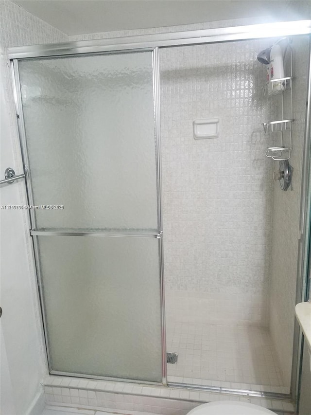 bathroom featuring a shower with shower door