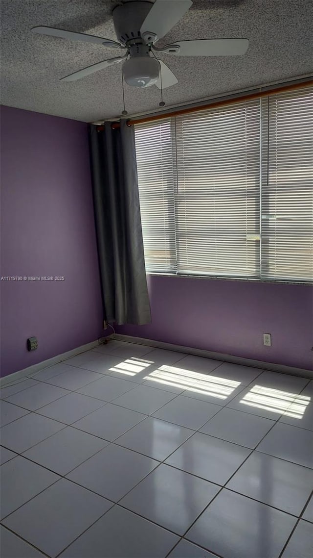 tiled spare room featuring ceiling fan