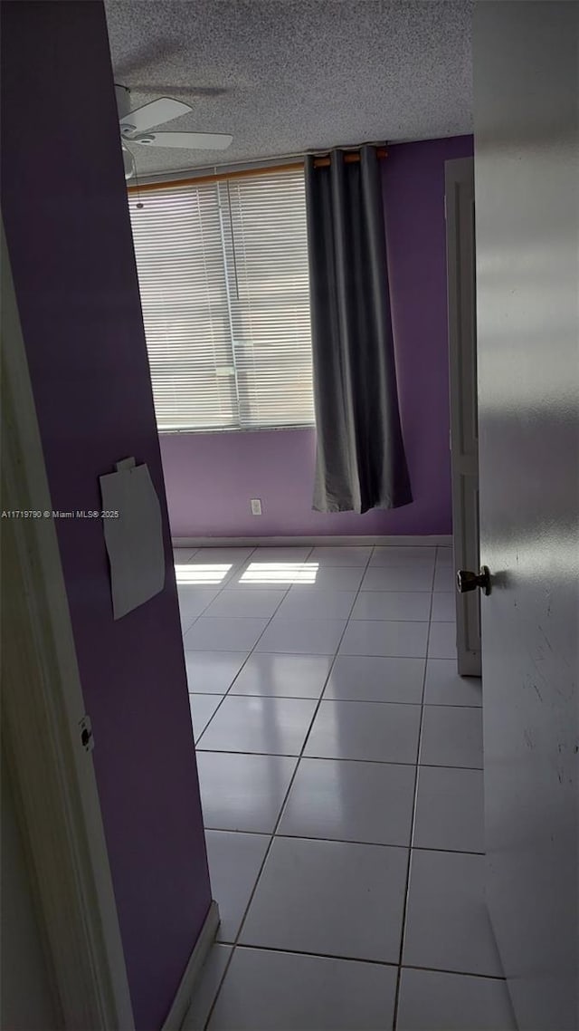 spare room featuring tile patterned floors and ceiling fan