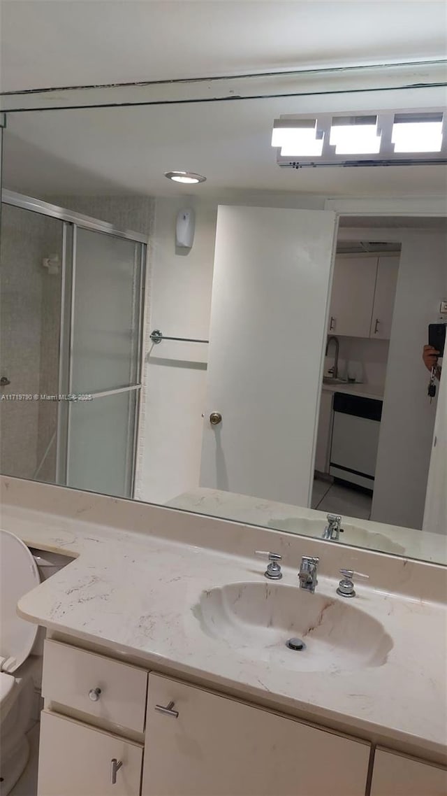 bathroom with a shower with door and vanity