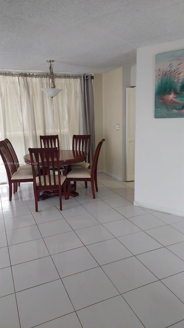 tiled dining area featuring a textured ceiling