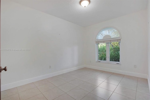 tiled spare room with a textured ceiling