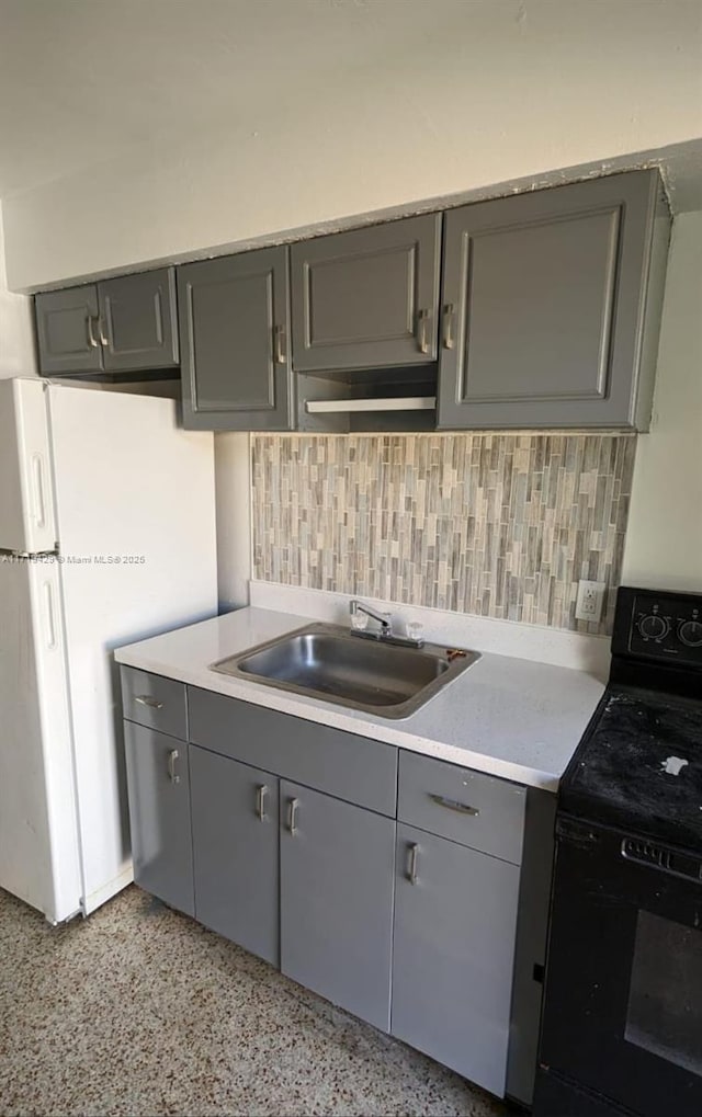 kitchen featuring tasteful backsplash, gray cabinets, electric range, and sink