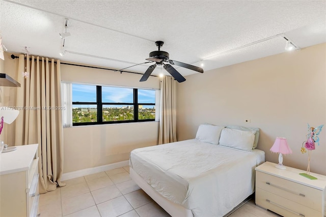 bedroom featuring ceiling fan, light tile patterned floors, a textured ceiling, and rail lighting