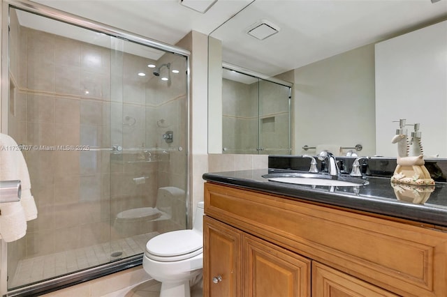 bathroom with tile patterned flooring, vanity, toilet, and a shower with door