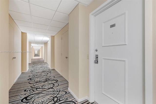 hallway with a paneled ceiling