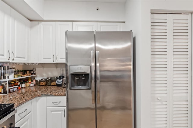 kitchen featuring stainless steel fridge with ice dispenser, dark stone countertops, and white cabinetry