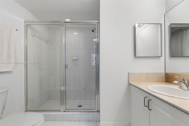 bathroom with toilet, vanity, tile patterned flooring, and a shower with door