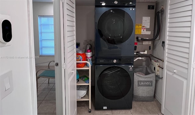 laundry room with light tile patterned floors and stacked washer and clothes dryer