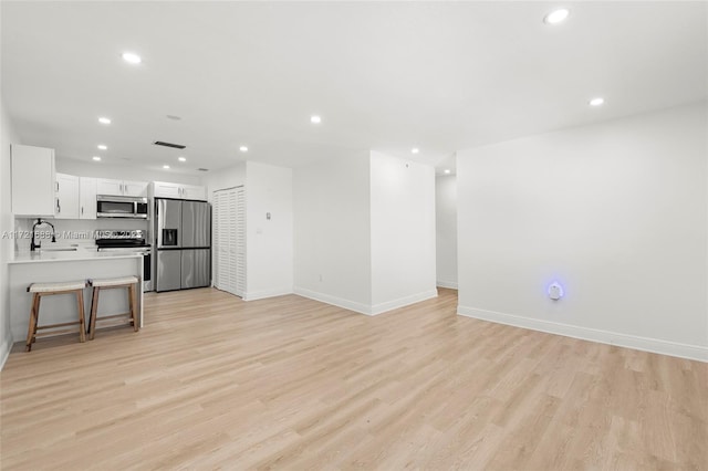 living room with sink and light hardwood / wood-style flooring