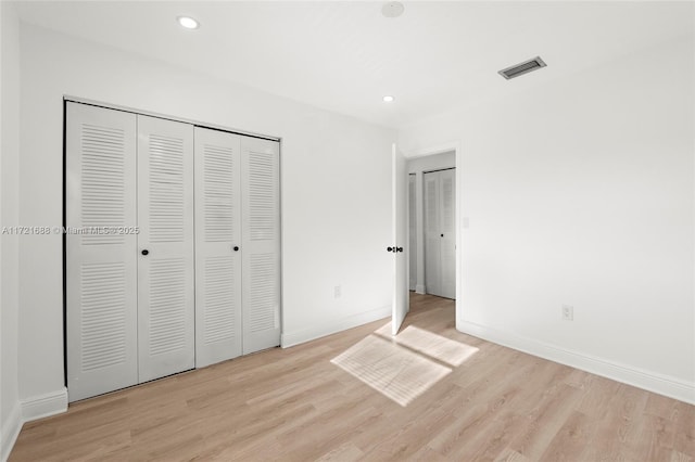 unfurnished bedroom with a closet and light wood-type flooring