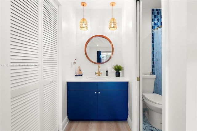 bathroom with hardwood / wood-style floors, vanity, and toilet