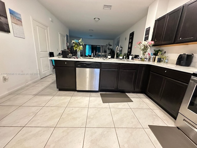 kitchen featuring a peninsula, light tile patterned floors, visible vents, and stainless steel dishwasher