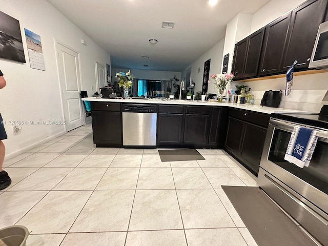 kitchen featuring a peninsula, light tile patterned floors, visible vents, and appliances with stainless steel finishes