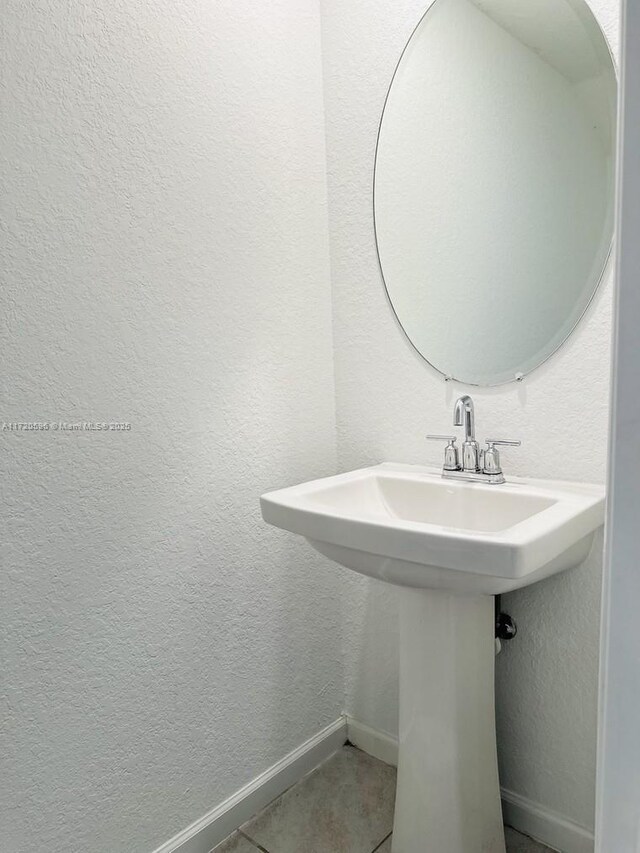 2944 NW 180th St, Miami Gardens, FL 33056 - bathroom with a sink, a textured wall, tile patterned flooring, and baseboards