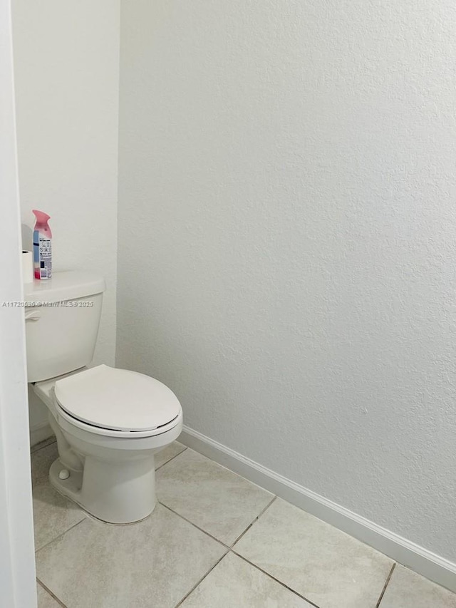 bathroom featuring baseboards, toilet, and tile patterned floors