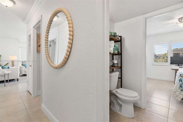 bathroom with tile patterned flooring, ceiling fan, toilet, and a textured ceiling