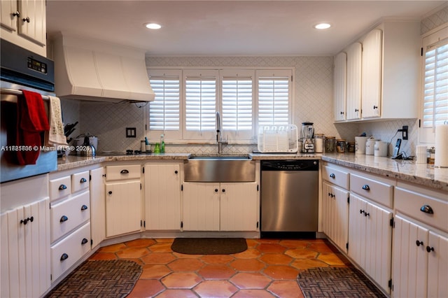 kitchen with sink, stainless steel appliances, backsplash, white cabinets, and custom range hood