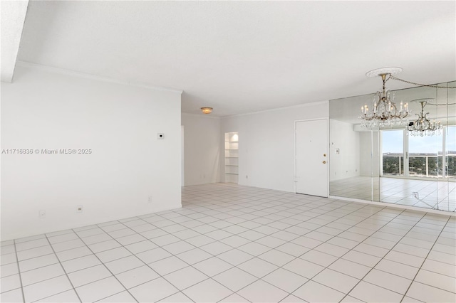 spare room featuring ornamental molding, light tile patterned floors, and a notable chandelier