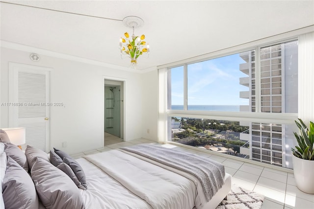 bedroom featuring light tile patterned flooring, a water view, and ornamental molding