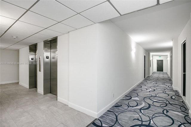 hallway featuring elevator and a drop ceiling