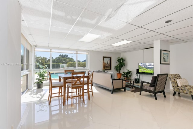 dining area with light tile patterned flooring and a drop ceiling