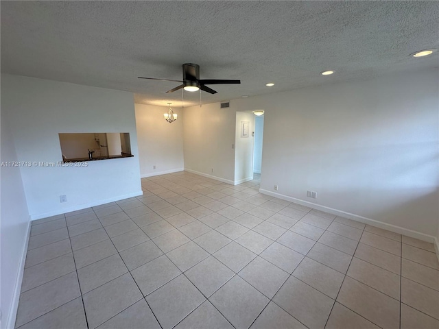 tiled empty room with ceiling fan and a textured ceiling