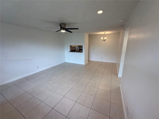 unfurnished living room with ceiling fan with notable chandelier and light tile patterned flooring