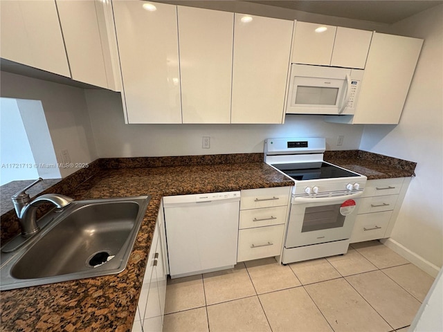 kitchen with white cabinets, light tile patterned floors, white appliances, and sink