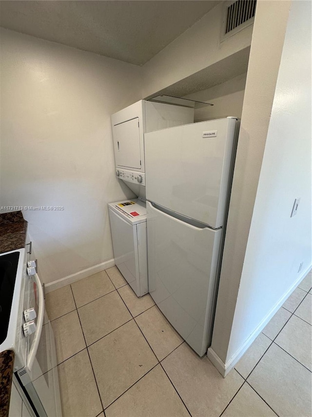 washroom featuring light tile patterned floors and stacked washer / drying machine