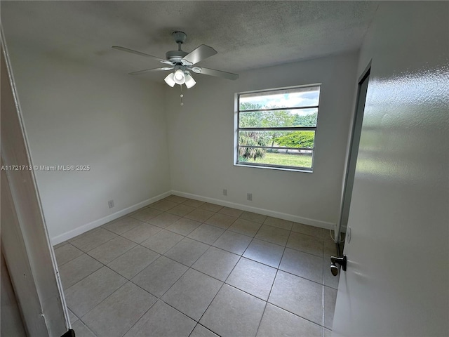 tiled empty room with ceiling fan and a textured ceiling