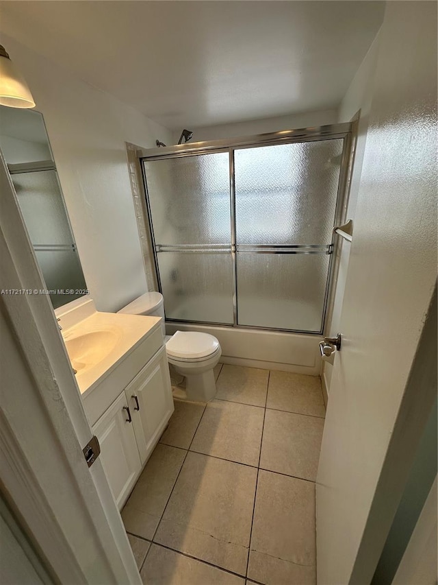 full bathroom with tile patterned flooring, vanity, toilet, and combined bath / shower with glass door