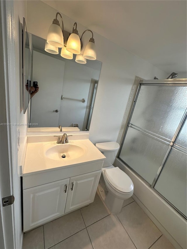 full bathroom featuring tile patterned floors, vanity, toilet, and bath / shower combo with glass door