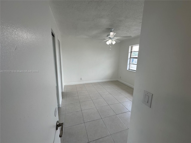 spare room with light tile patterned floors, a textured ceiling, and ceiling fan