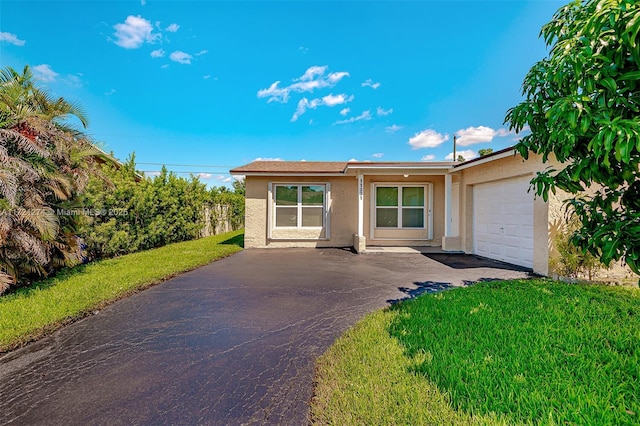 single story home with a garage and a front lawn