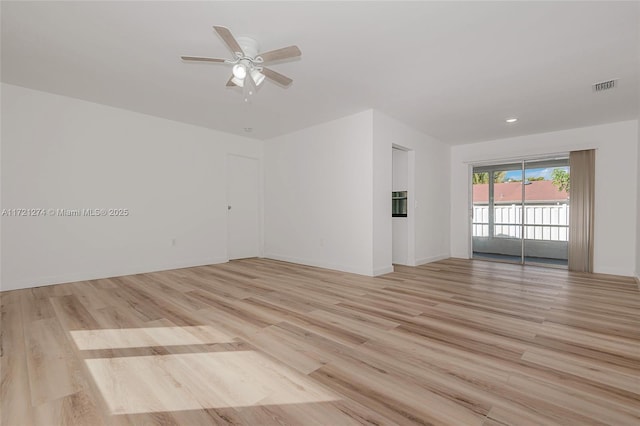 empty room with ceiling fan and light hardwood / wood-style flooring