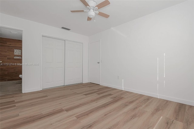 unfurnished bedroom featuring a closet, ceiling fan, and light hardwood / wood-style flooring