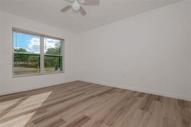 empty room with ceiling fan and light hardwood / wood-style flooring