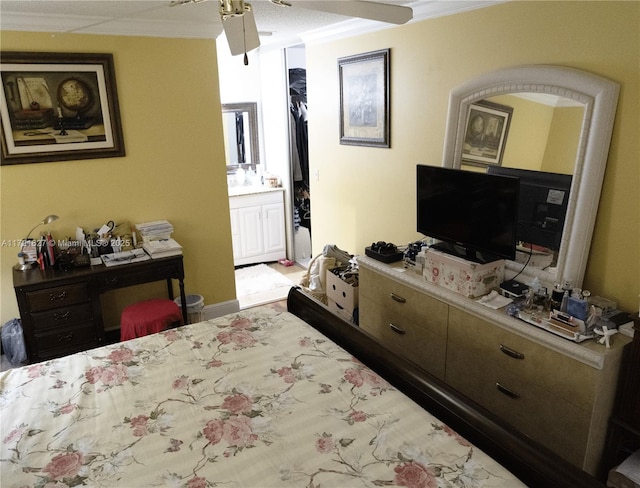 bedroom featuring ceiling fan, crown molding, and ensuite bath