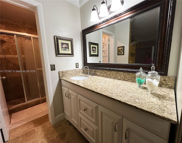 bathroom with a shower with door, ornamental molding, and vanity