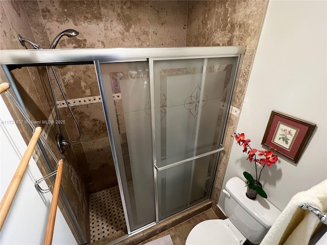 bathroom featuring toilet and an enclosed shower