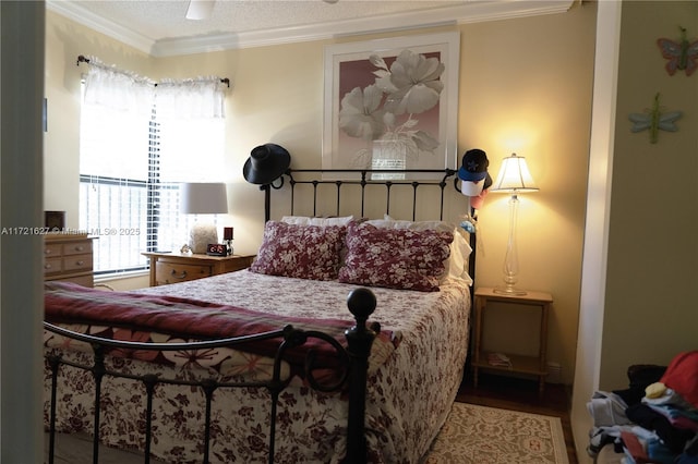 bedroom with hardwood / wood-style flooring, ornamental molding, and ceiling fan