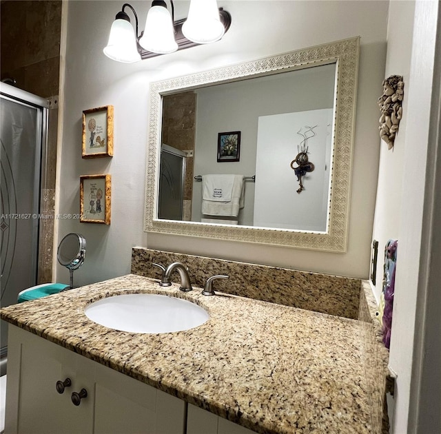 bathroom with a shower with door and vanity