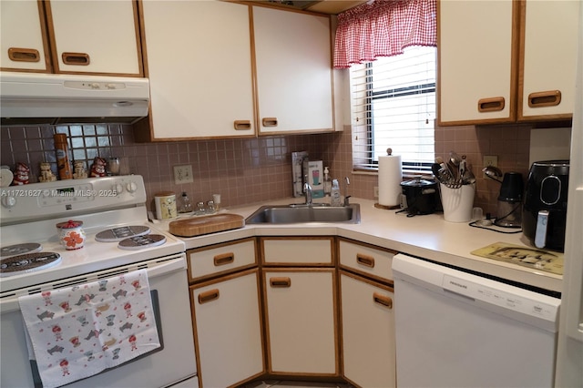 kitchen featuring white appliances, tasteful backsplash, white cabinetry, and sink