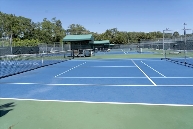 view of tennis court with basketball hoop