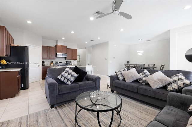 living room featuring ceiling fan, light tile patterned floors, and sink